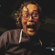 A man screams while being filmed by a video camera.